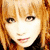 Pixelated image of a person with light brown hair and bangs, next to pink floral background with text.