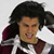 Pixelated static image of a person with dark curly hair wearing a maroon and white sports jersey, mouth open in mid-expression against light background.