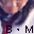 Pixelated image showing two figures in dark clothing with a central white vertical element, overlaid text 'B·M' and partial 'M' on lower left.