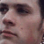 Pixelated close-up of a person's face showing eyes, nose, and mouth with muted brown and pink tones.