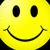 Yellow circular face with black oval eyes and curved smile, displayed in a of four identical copies against dark background