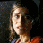 A 48x48 pixel buddy icon split into two sections: a left-side portrait of a person with light brown hair and an orange top against a dark background, and a right-side green section with bright green text reading "Original Icons .com" in a stylized font.