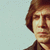 Pixelated portrait of a person with brown hair and a dark collar, split across two with a light blue background on the left and gray on the right