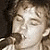 A split-screen image shows a person singing into a microphone on the top left and a figure walking toward water on the bottom left, with text reading 'marc broussard .com' in two sections.