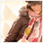 Pixelated image of a person in a brown jacket and red shirt holding a yellow object against a light background.