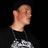 A person in a black shirt with white text stands against a dark background, transitioning from side profile to front view while displaying text overlays.