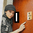 A person in a black cap and camouflage jacket points at a light switch on a brown door, with text overlays changing