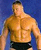 A pixelated image of a shirtless man with short dark hair standing against a blue background, wearing black shorts.