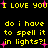 Yellow pixelated text on black background with pink starbursts, repeating 'I LOVE YOU' and 'do i have to spell it in lights?!'