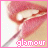 Pixelated close-up of lips holding a lollipop with pink icing, framed by a solid pink border and the word 'glamour' in pixelated text below.