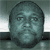 A pixelated image of a person's face above a white infinity symbol on a dark background, with a reflection below.