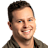 Pixelated portrait of a person with short dark hair, light skin, and a neutral expression against a gray background.