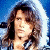 Two side-by-side pixelated images of a person with long wavy brown hair against a blue background, showing subtle differences in lighting and facial expression.