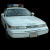 Three pixelated frames of a white police car with blue and red lights on top, displayed in a 2x2 contact sheet layout against black background with one gray square.