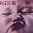 A pixelated image of a baby's face with closed eyes and mouth open in an animated sequence, text above reads 'k:iss me' in alternating dark and light pink letters.