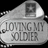 A silver dog tag with 'LOVING MY SOLDIER' text and a small photo, surrounded by yellow pixelated text reading 'my daddy wears combat boots' and 'Support our troops' on a black background.