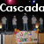 Pixelated image showing a group of figures in gray shirts and blue pants standing behind a table with colorful items, under text reading "Cascada" and "Boys."