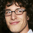 Pixelated image of a person with curly hair and glasses, next to pixelated text reading "Andy Samberg Is My Jesus" on black background.