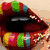Animated sequence showing a mouth with colorful candy-like objects, transitioning to a heart symbol on a metallic surface.