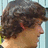 A six- shows a person with brown curly hair turning their head left to right , accompanied by pixelated text blocks