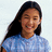 A pixelated image of a person with long dark hair wearing a light blue patterned shirt against a white background, next to the text 'evy' in blue pixels.