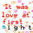 Pixelated text "It was love at first sight" repeated in red and black with pink heart motifs on a white background, animated by color shifts.