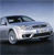 Pixelated image of a silver sedan with dark tinted windows, positioned at a three-quarter angle against a gradient sky background.