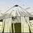 Pixelated image of a building with and a triangular roof, next to blue text on black background