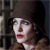 A pixelated close-up of a person with dark hair wearing a brown hat and brown clothing, red lips, and a dark background with vertical lines.