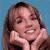 Static pixelated image of a person with long brown hair against solid blue background, hands resting on cheeks in a pose.