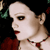 A woman with dark hair and red lips wears a necklace, her clothing changes from red to patterned fabric across six