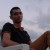 Pixelated image of a person in a dark sleeveless top against a light sky background with blurred horizontal elements.