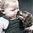 A 48x48 pixel animated contact sheet showing two frames of a baby holding an animal against a dark background, with green text reading "Original Icons .com" on the right side.
