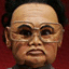 Static pixelated image of a person with short dark hair, light skin tone, and glasses against a solid red background.