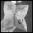 A grayscale icon of a person in a white shirt and dark pants, viewed from the waist up against a dark background.