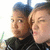 Two people in dark clothing with light hair, one person's face shifts from neutral to squinting expression across frames.