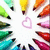 Colorful pencil icons arranged in a circular pattern around a central pink heart on white background.