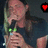 A pixelated image of a person holding a microphone with green lights, featuring red text and a heart symbol.