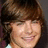 A static image shows a person with brown hair and a light-colored top against a blue background with pink text reading "Mrs.", "Angelo", and "Effron".