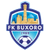 Pixelated shield-shaped icon with blue border, cityscape in upper section, soccer ball in lower section, and text banner across middle.