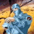 A pixelated figure in blue tones holds a light-colored object against a yellow and brown background with dark accents.
