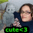 A person in a dark blue turtleneck holds two gray plush toys against a light background, with green text reading 'cute<3' visible below.