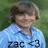 Pixelated image of a person with short brown hair wearing a light blue shirt against a green background.