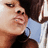 Pixelated close-up of two people in profile view, one with dark hair and light blue clothing, the other with lighter skin tones and dark clothing, both facing left.