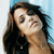 Pixelated close-up of a person with long dark hair, light skin tone, and closed eyes against a blue background.