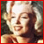 Marilyn Monroe in a vintage-style portrait with blonde curls, smiling and sticking out her tongue