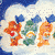 Animated sequence of colorful Care Bear-like figures with blue cloud-shaped ears against a cloudy sky background, each holding distinct symbols.