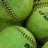 Green softballs with visible stitching and text on a purple background, accompanied by pixelated text phrases.