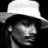 A 48x48 pixel animated contact sheet showing two frames: a grayscale portrait of a person wearing a white cowboy hat on the left and a red classic car with orange accents on the right, both against black backgrounds.