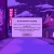 Pixelated purple and pink scene with a central white rectangular box containing blurred text lines and a button-like shape below.